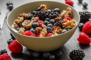 Quark-Bowl mit verschiedenen Beeren und Walnüssen.