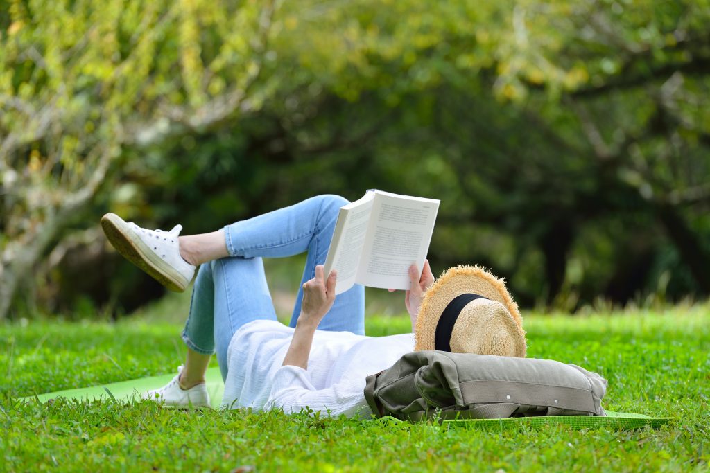 Beim Lesen draußen auf einer Wiese lässt es sich hervorragend abschalten.