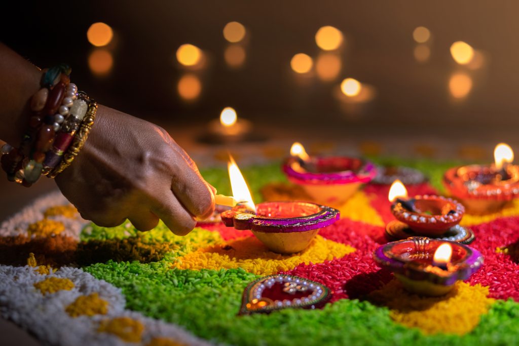 Kleine Öllämpchen werden auf einem Rangoli angezündet