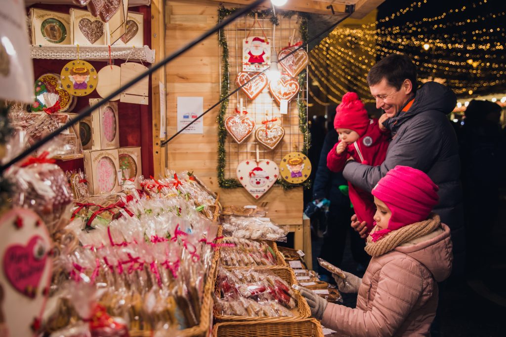 Eine Familie schaut sich die Handwerkskunst auf dem Weihnachtsmarkt an