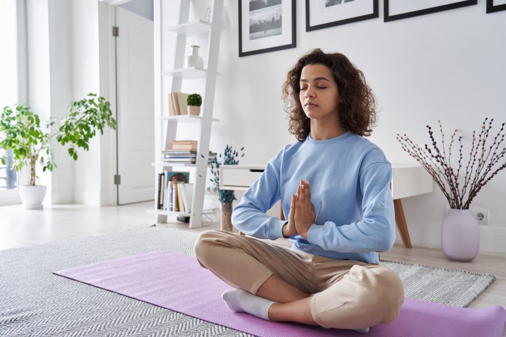 Frau meditiert auf Yoga Matte