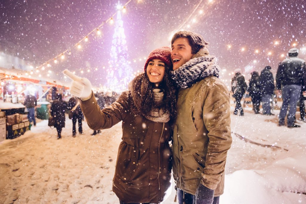 Paar auf einem verschneiten Weihnachtsmarkt