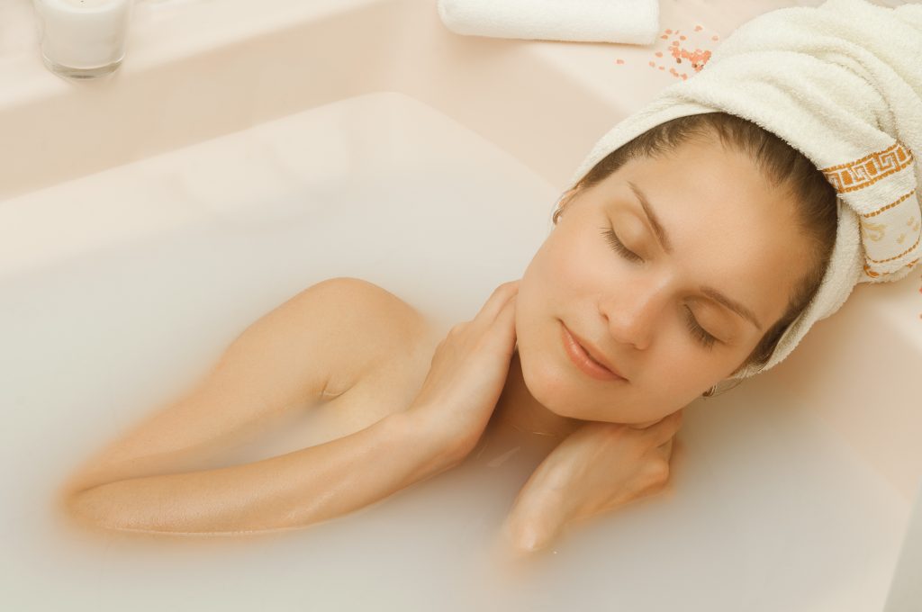 Frau nimmt ayurvedisches Bad abends gegen Schlafstörungen