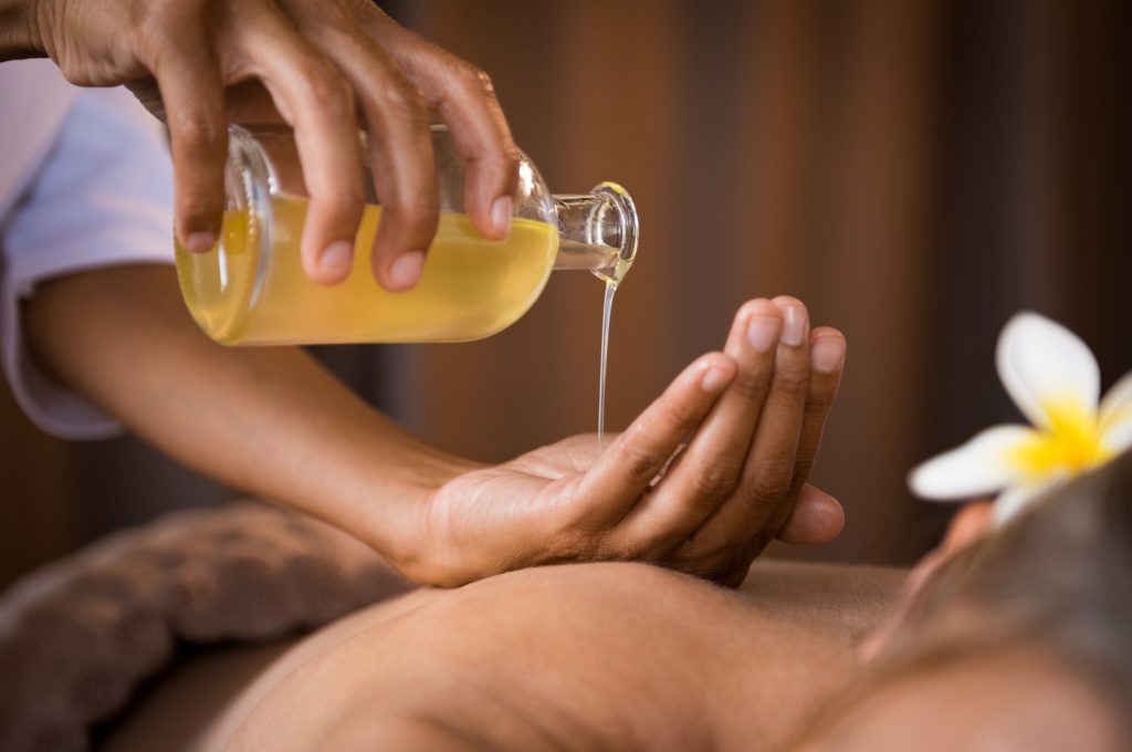 Ayurveda gegen Hautkrankheiten - Therapeut gießt Öl in seine Hand
