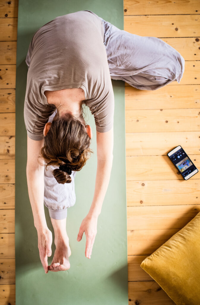 Frau macht Yoga zuhause