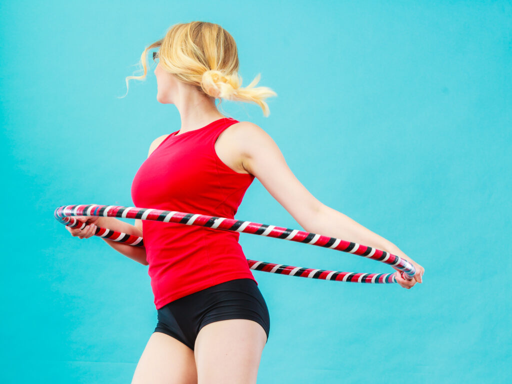 Frau mit Hula-Hoop Reifen und rotem T-Shirt. 