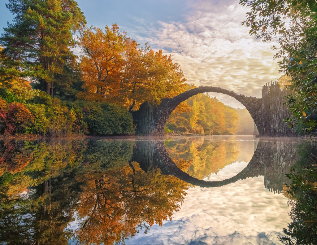 Die bogenförmige Rakotzbrücke, die sich in der Flusswasseroberfläche spiegelt 