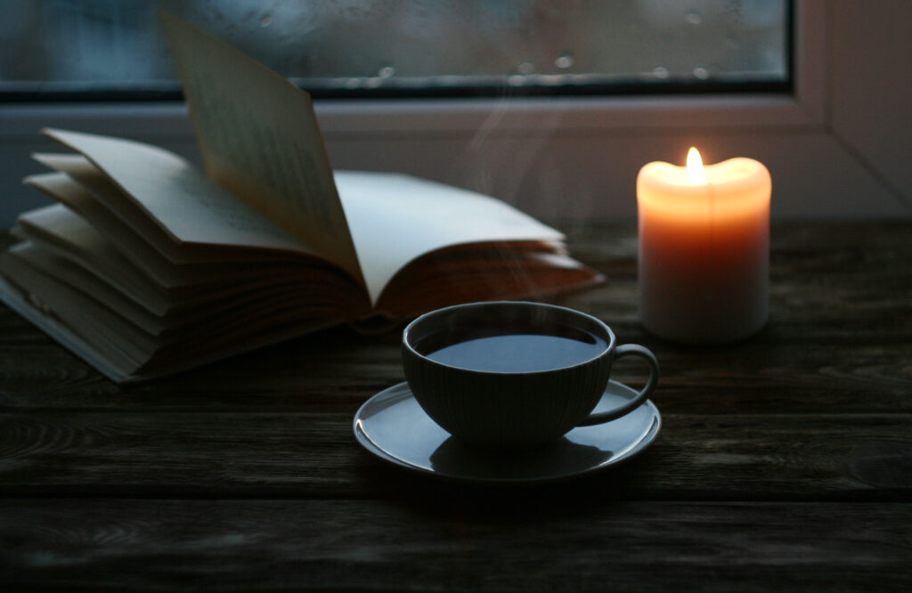 Tisch mit einem Buch, einer Kerze und einem Tee
