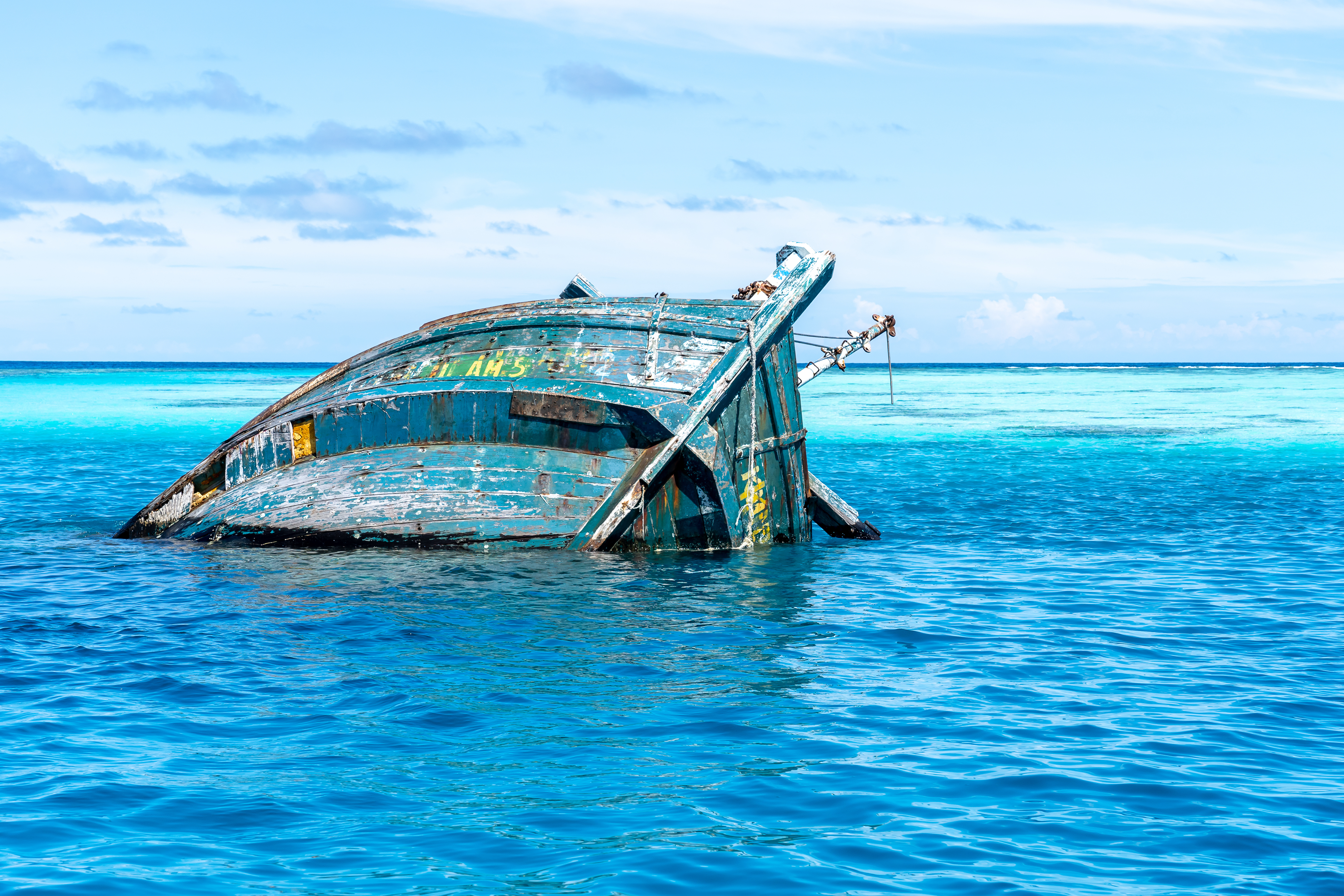 Sehenswürdigkeit Malediven, Buntes altes Schiff, das teilweise aus dem Wasser herausragt