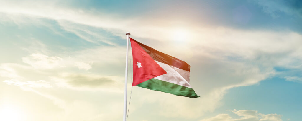 Wehende Flagge von Jordanien vor einem schönen Himmel.
