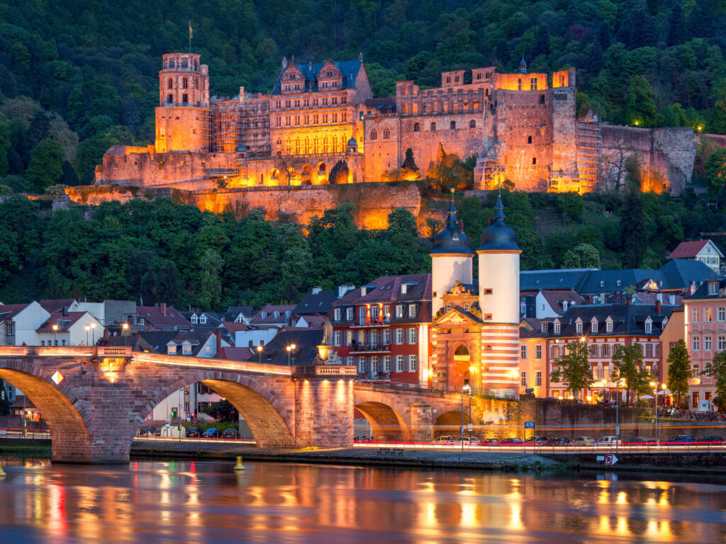 Das beleuchtete Schloss Heidelberg über den Dächern der Stadt in der Nacht