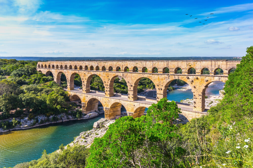 Das römische Aquädukt Pont du Gard, eine Brücke, die einen Fluss überquert und aus drei Ebenen mit unterschiedlich großen Bögen besteht 