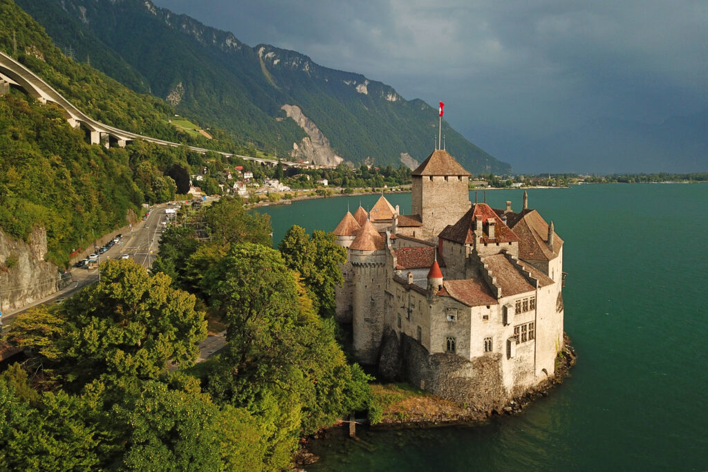 Das mittelalterliche Schloss Chillon, Sehenswürdigkeit auf einer kleinen Felsinsel im Genfersee, Berge und See im Hintergrund