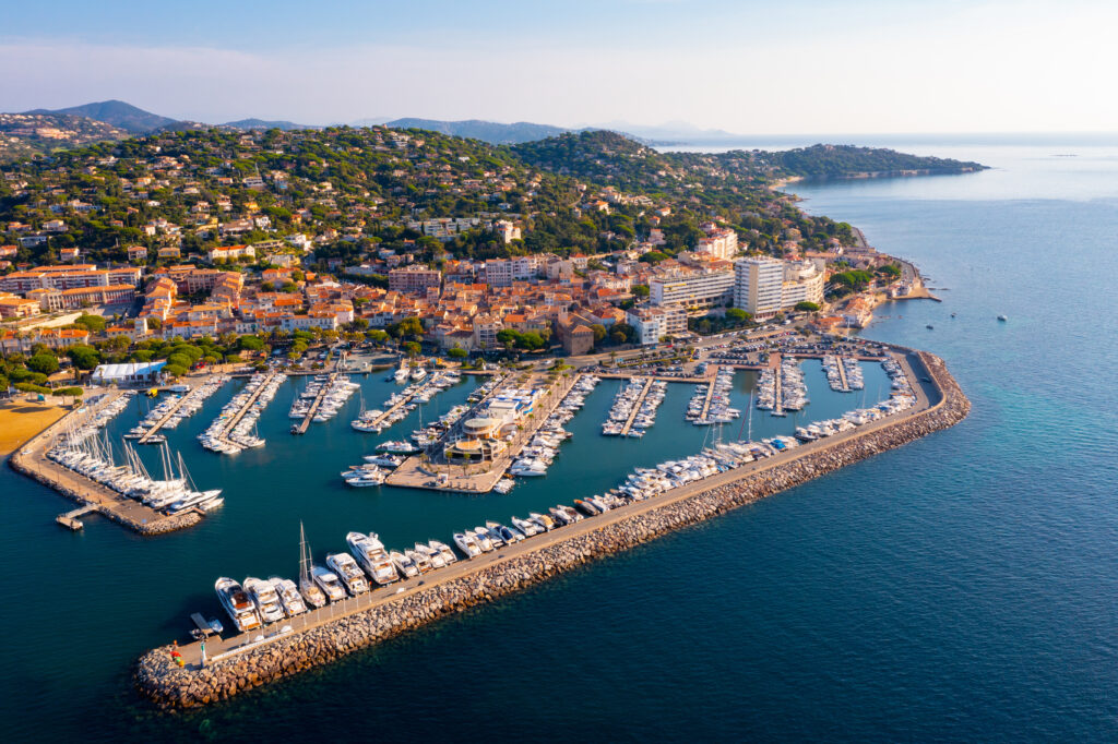 Saint-Tropez an der Mittelmeerküste, im Vordergrund ein großer Yachthafen und im Hintergrund eine hügeligen Landschaft