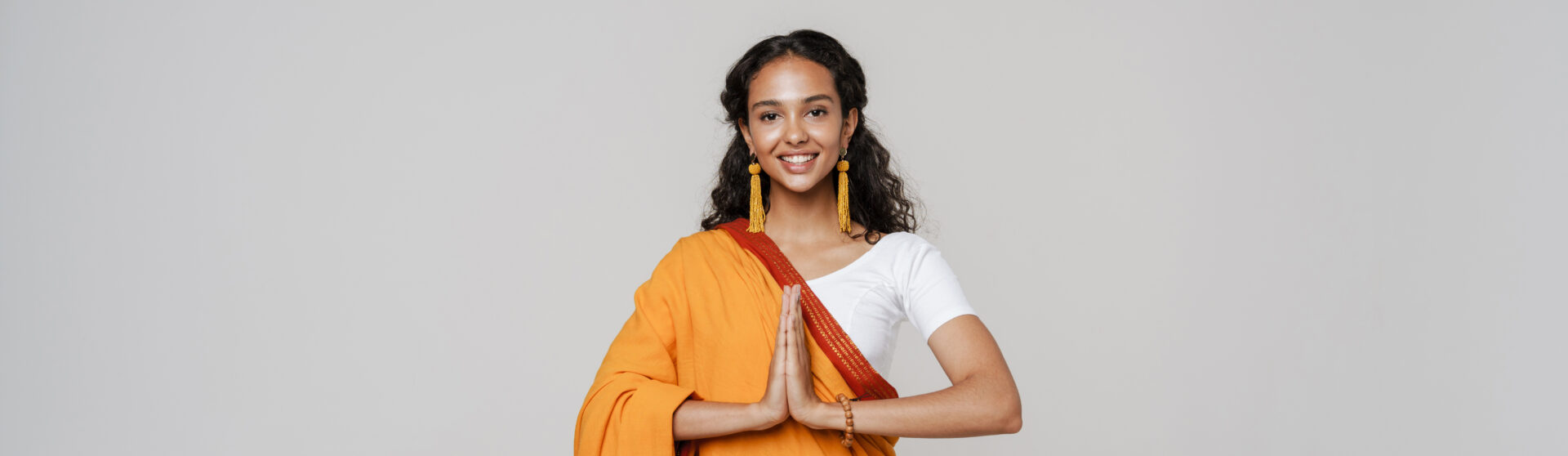 Indische Frau führt das Anjali Mudra aus beim Namaste