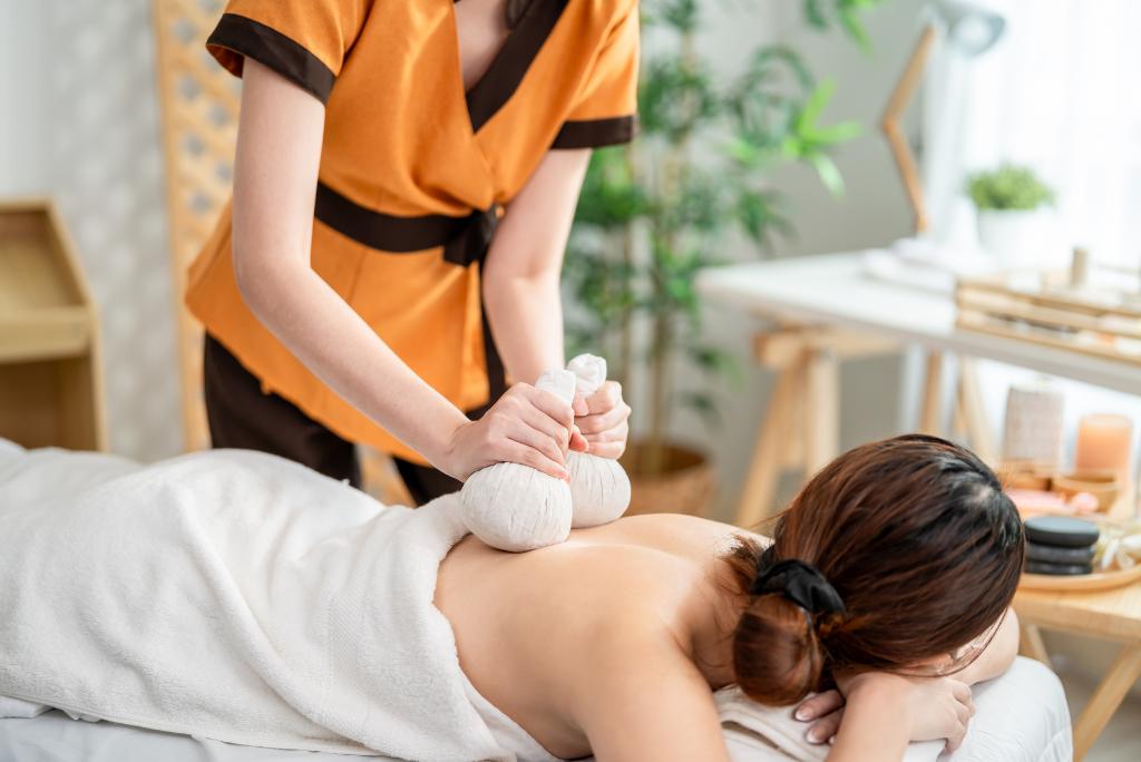 Eine Frau bei der Kräuterstempelmassage