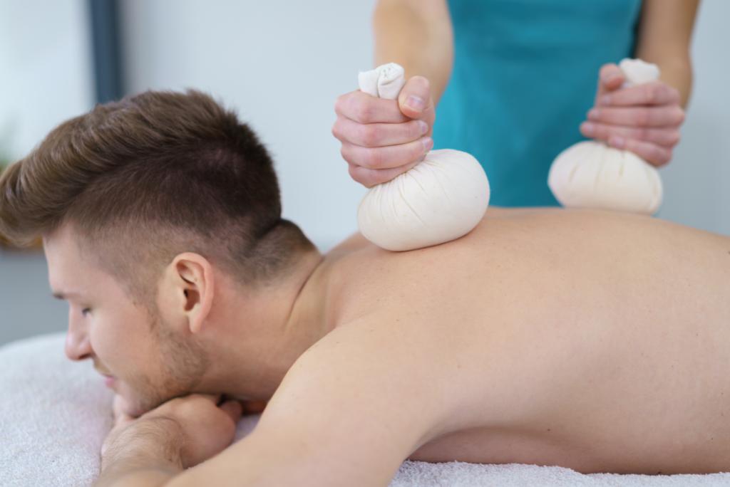 Ein Mann bei der Kräuterstempelmassage