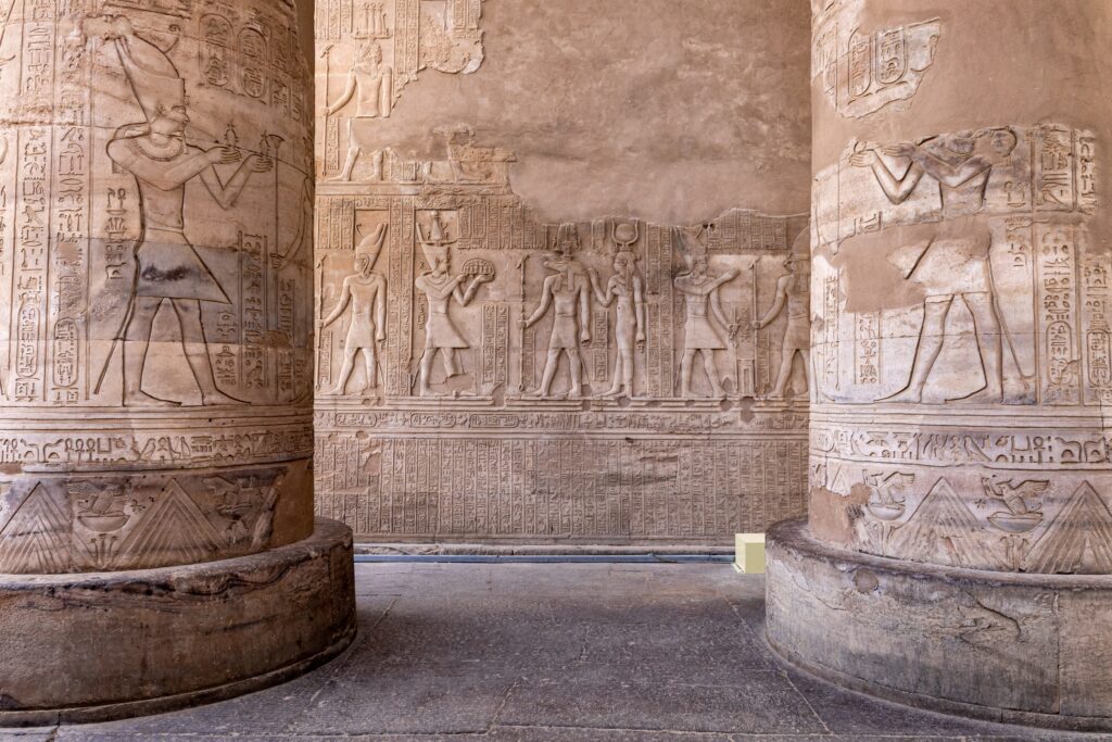 Verzierte Säulen und eine Wand mit antiken Reliefs im Doppeltempel von Kom Ombo