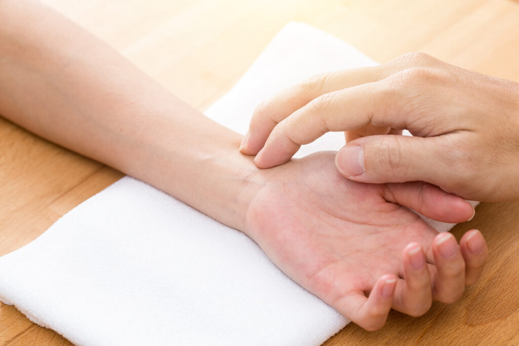 Eingehende Pulsdiagnose als Teil der Tuina Therapie
