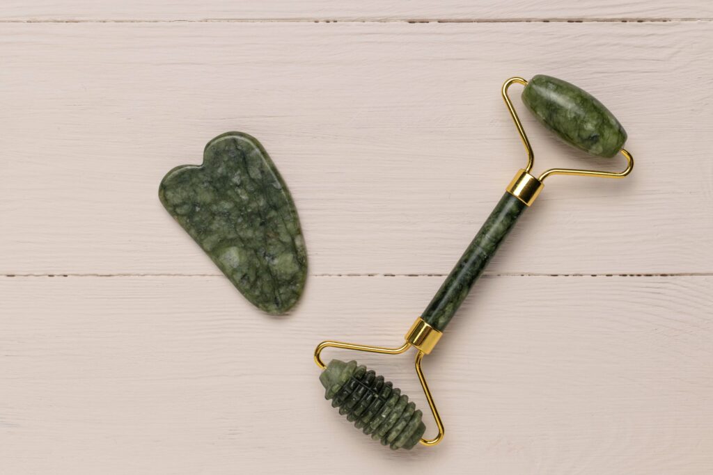 Eine Gua Sha Stein und ein Gesichtsroller aus Jade