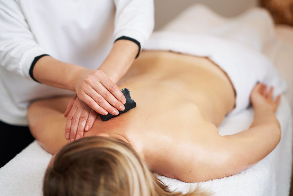 Eine Frau bei der professionellen Gua Sha Rücken-Massage