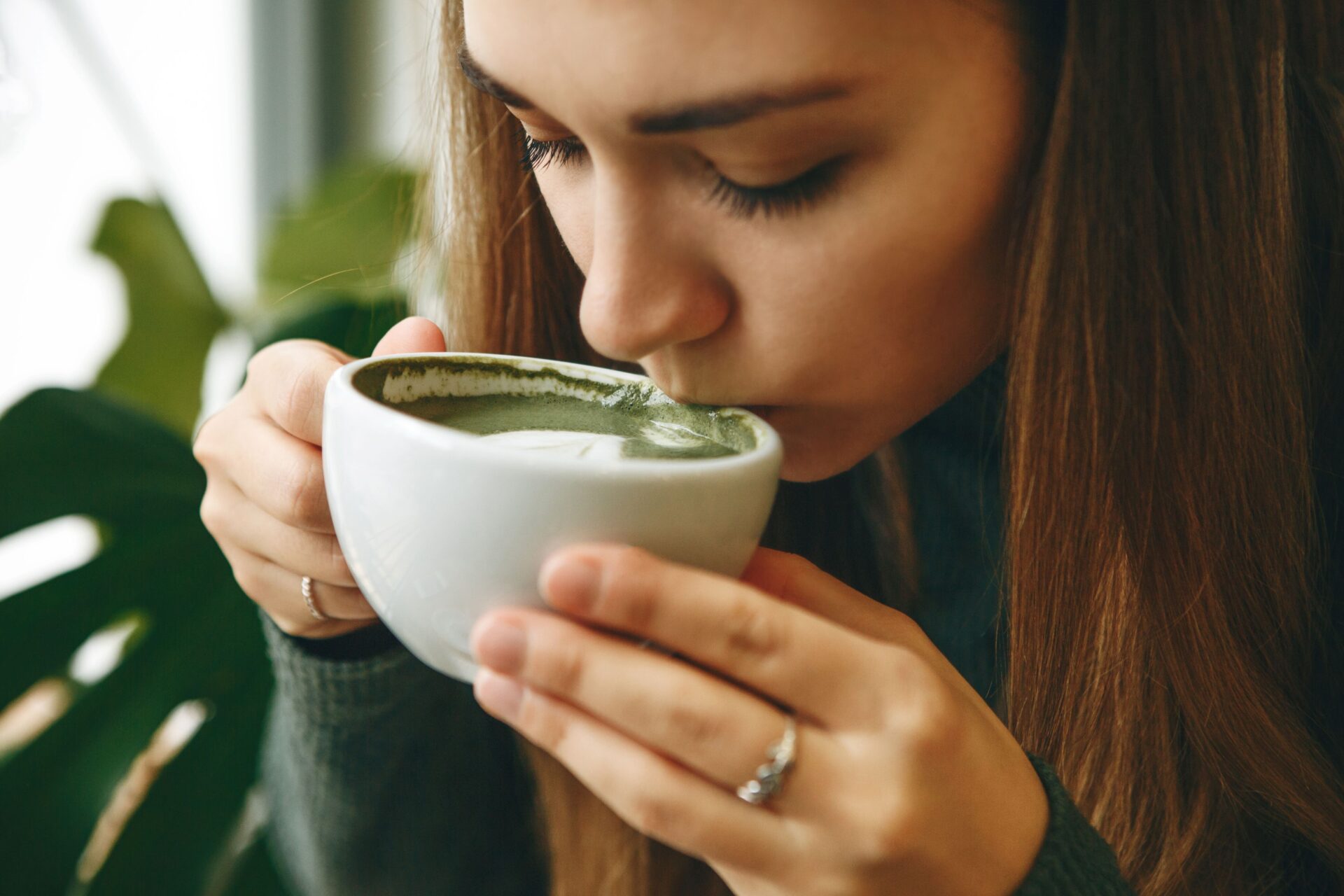Eine Frau trinkt genüsslich Matcha