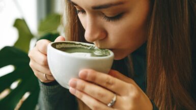 Eine Frau trinkt genüsslich Matcha