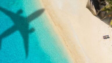 Der Schatten eines Flugzeugs am Tropenstrand