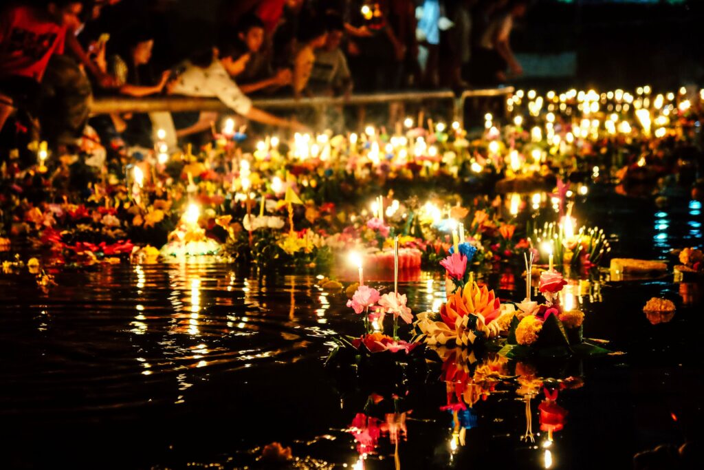 Hunderte kleine Boote auf einem Fluss, feiernde Menschen stehen am Rand