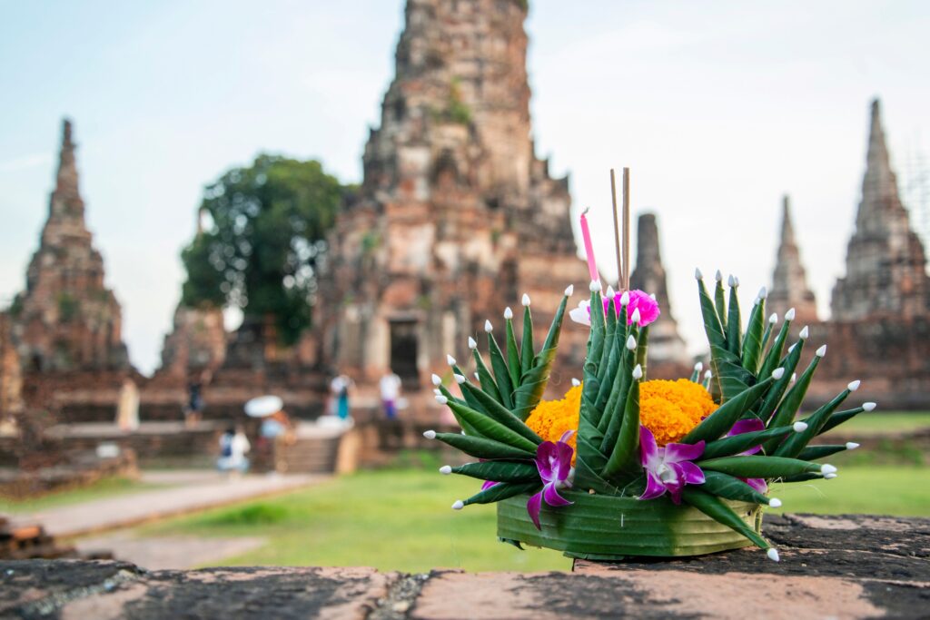 Ein Krathong, im Hintergrund ein Tempel in Ayutthaya 